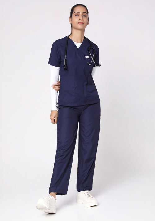 Front view of a model in the Knya Classic V-Neck Scrub Top and pants in navy blue